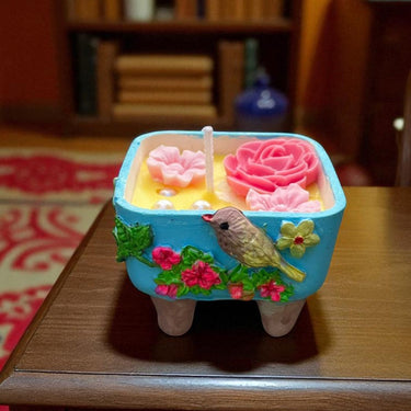 Decorative item with flowers and a bird on a wooden surface