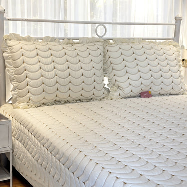 white quilted bedcover with frills | side view