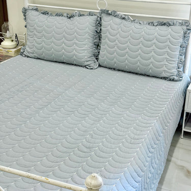 Blue 3-piece quilted bedcover set with frilled pillow covers | left side view