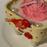 Handcrafted Bird & Blossom Cement Candle | Ivory Gold Holder with Pink Floral Wax Design Closeup view