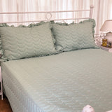 green quilted king size bedcover with frills | side view